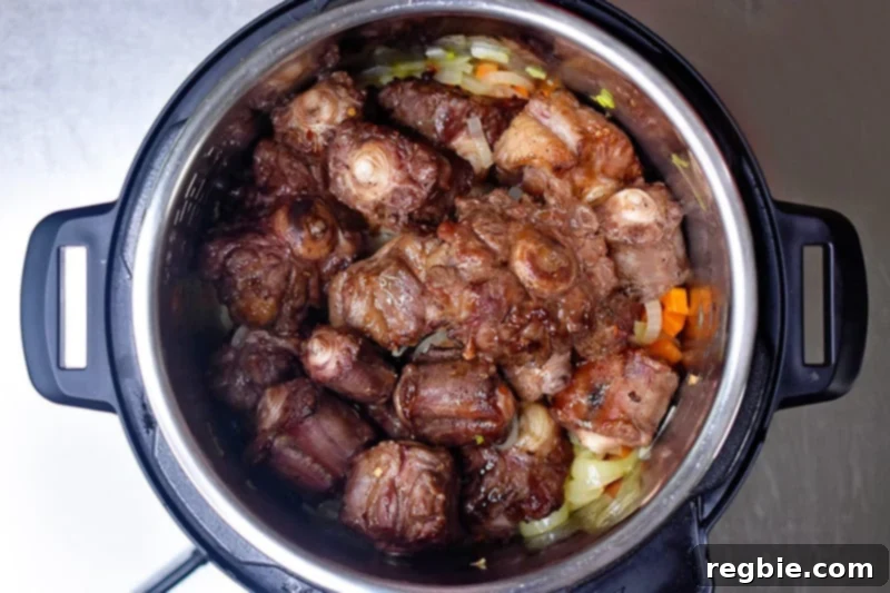An overhead shot of Instant Pot Oxtail Stew in an open Instant Pot before it is programmed to cook under high pressure.