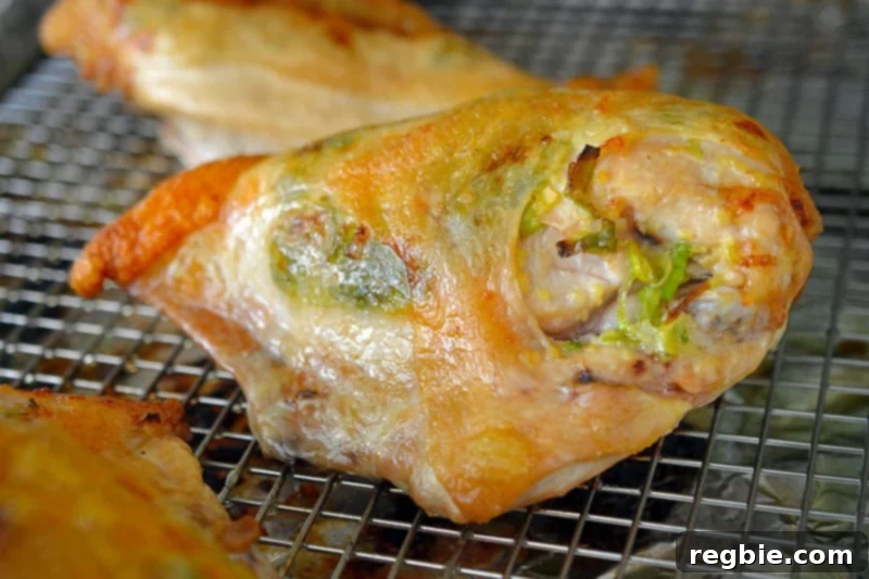 A closeup shot of the perfectly cooked Ginger-Scallion Chicken, fresh out of the oven, with golden crispy skin.