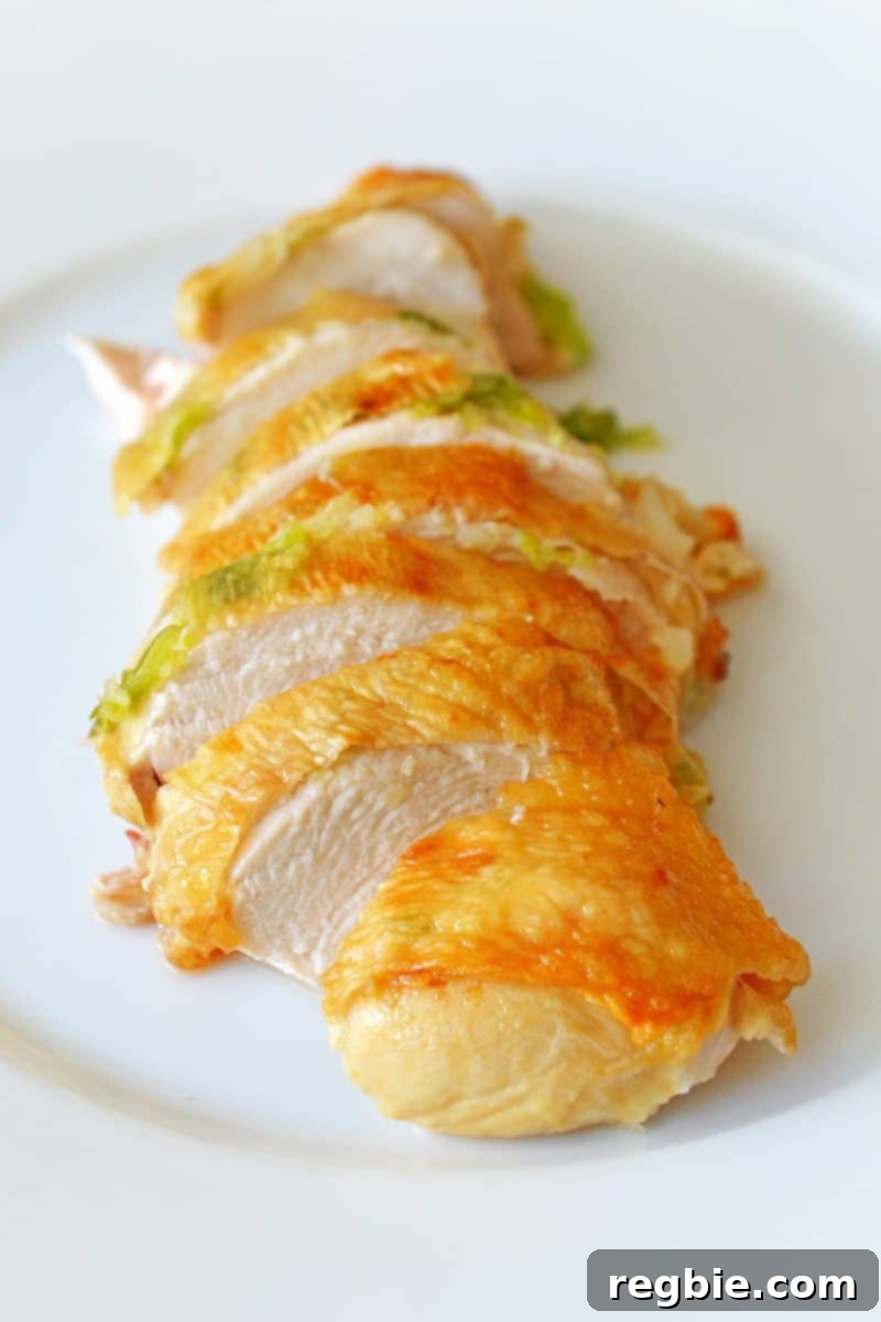 Deliciously sliced Ginger-Scallion Chicken presented on a pristine white plate, ready to be enjoyed.
