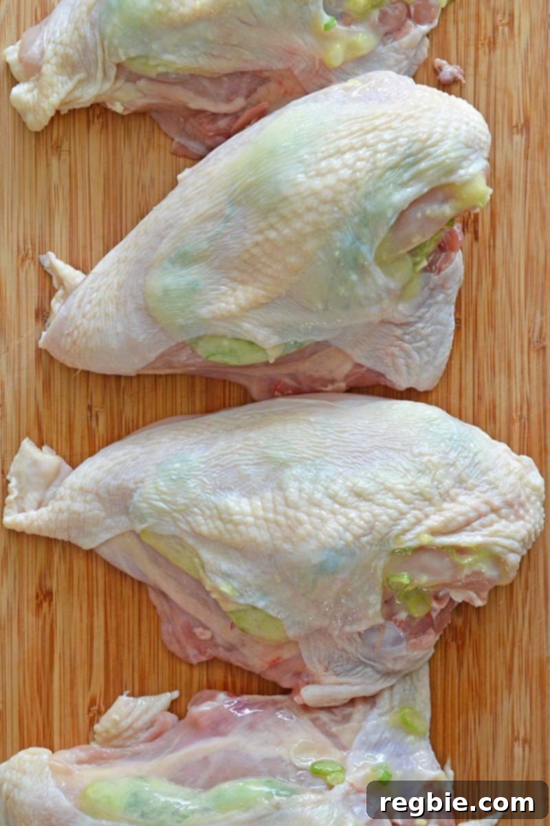 An overhead shot of uncooked Ginger-Scallion Chicken with the sauce evenly distributed under the skin, ready for cooking.