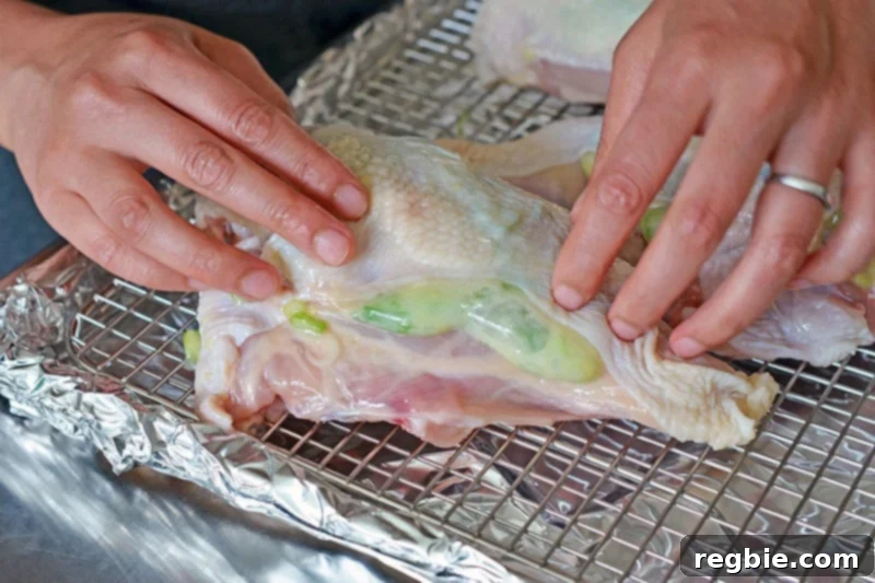 Ginger-Scallion Chicken breasts arranged on a stainless steel wire rack atop a foil-lined rimmed baking sheet.