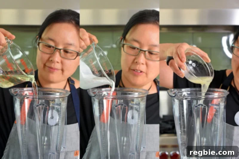 Pouring the liquid ingredients for the No-Bake Matcha Cheesecake filling into a high-powered blender.