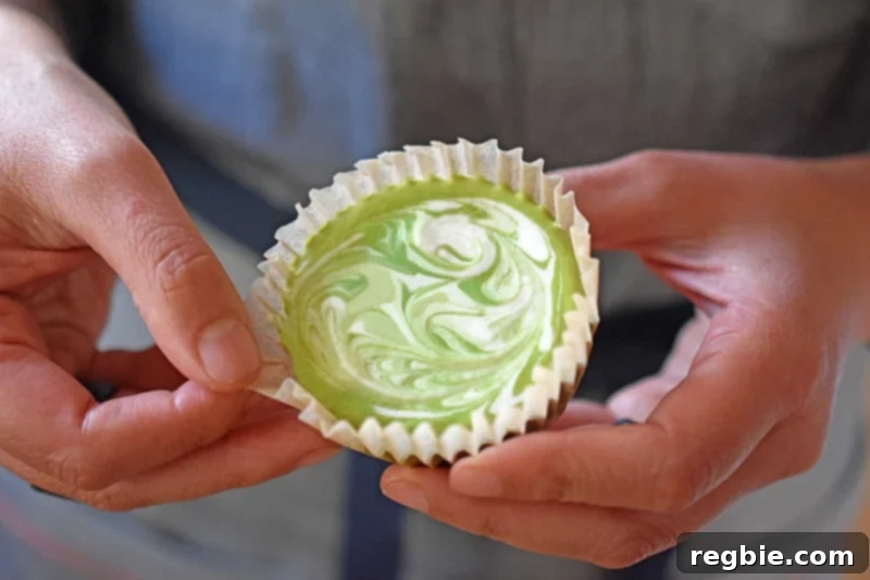 A paleo and vegan No-Bake Matcha Cheesecake cupcake, perfectly portioned and ready to be eaten.