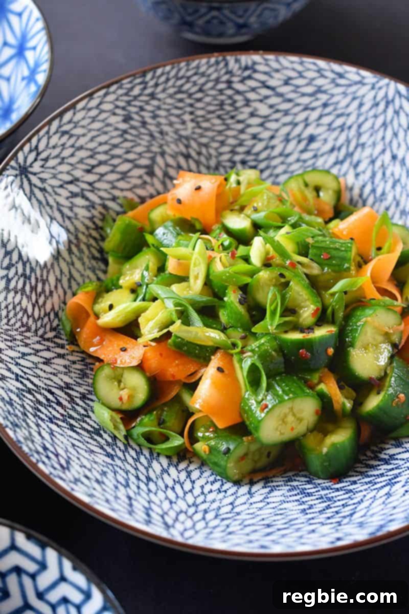A close up of the paleo and whole30 smashed cucumber and carrot salad recipe in a bowl, showcasing its fresh ingredients and vibrant colors.