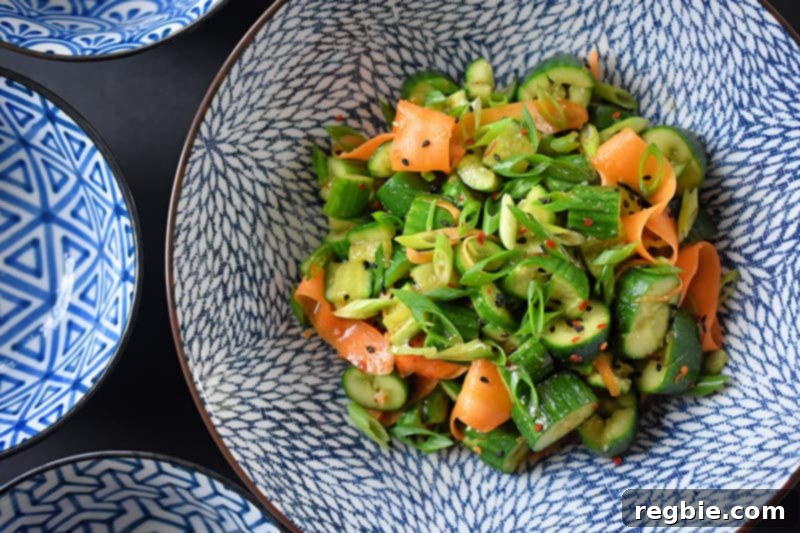 An overhead shot of paleo and whole30 smashed cucumber and carrot salad, beautifully arranged in a serving bowl.