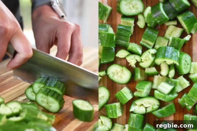 Chopping salt covered and smashed cucumbers into one inch pieces on a cutting board.
