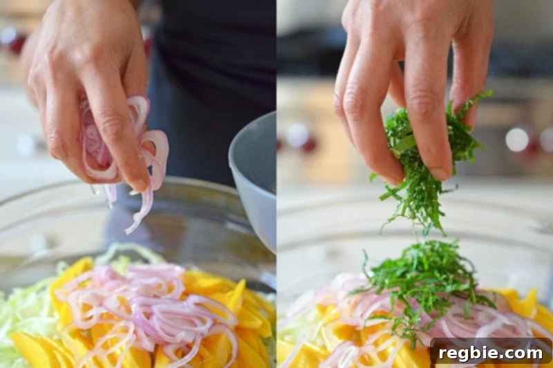 Zesty Mango Cabbage Crunch 6 Someone adding soaked shallots and sliced mint into a large glass bowl containing mango and cabbage.