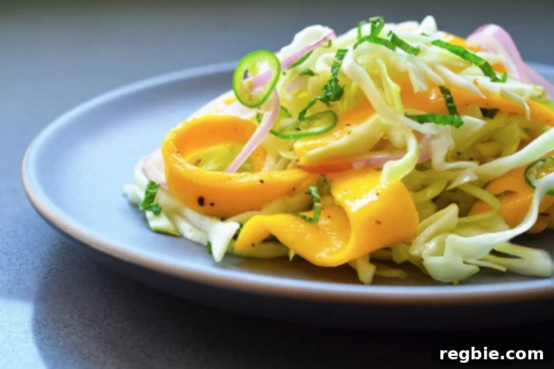 Zesty Mango Cabbage Crunch 9 A generous pile of paleo spicy mango cabbage slaw served on a white plate, ready to be devoured.