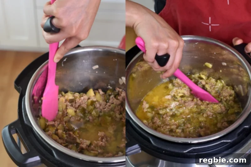 A pink silicone spatula being expertly used to mash the cooked zucchini directly in the Instant Pot, creating a smooth, rich sauce base.