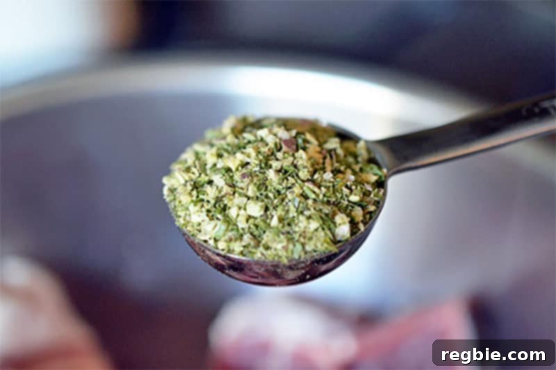 A spoonful of aromatic Sunny Paris Seasoning, poised to flavor the cubed pork in the Slow Cooker Cheater Pork Stew.