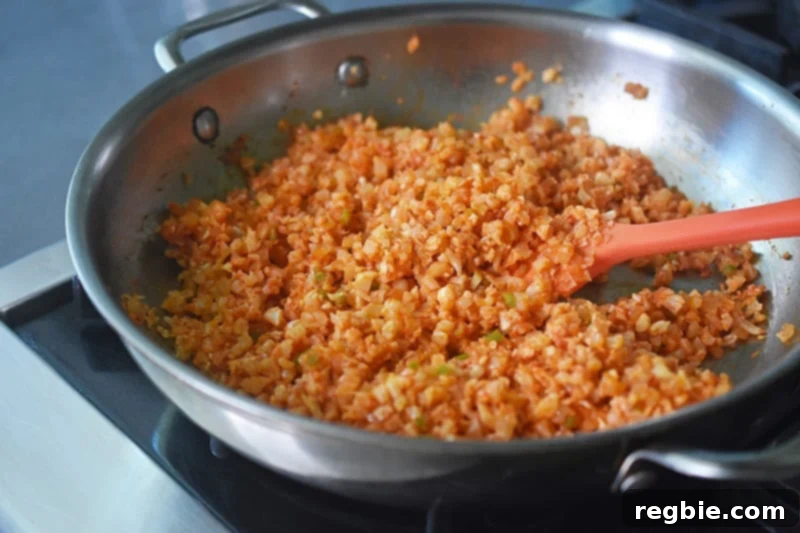 An inviting overhead shot reveals the perfectly cooked Mexican Cauliflower Rice, beautifully seasoned and ready in the pan.