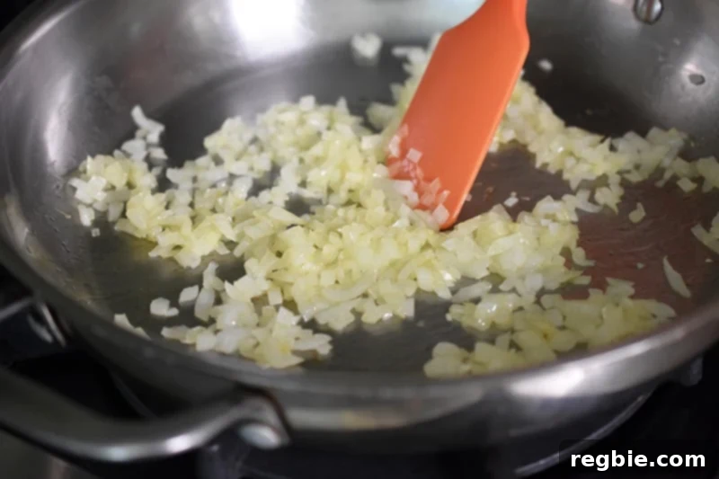 The minced onions are cooking until perfectly softened in the pan, releasing their sweetness for healthy Mexican Cauliflower rice.