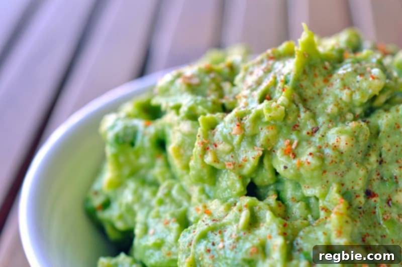 Avocado Dream Dip 9 A large bowl of vibrant green guacamole is shown generously sprinkled with red Aleppo pepper on top for a beautiful and flavorful finishing touch.