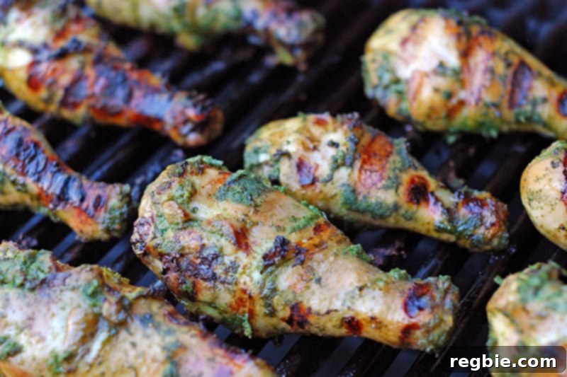 Perfectly cooked Fiona’s Phenomenal Grilled Green Chicken with crispy, charred skin resting on the grill grates.
