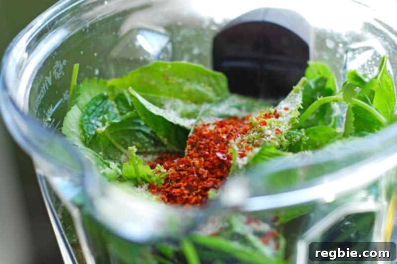 All the vibrant ingredients for the Whole30 and Paleo-friendly Green Chicken marinade collected in a blender, ready for blending.