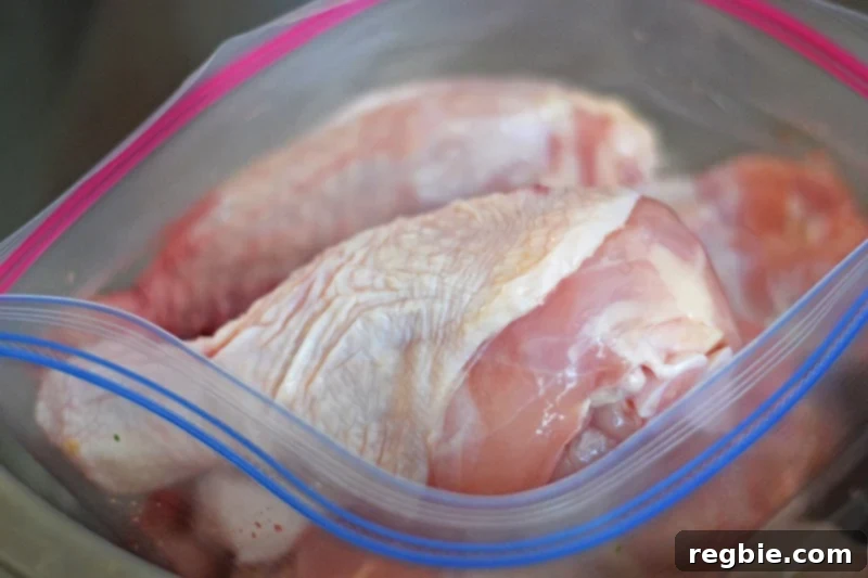 Raw chicken drumsticks and thighs placed inside a large, food-safe Ziplock bag, ready for marination.