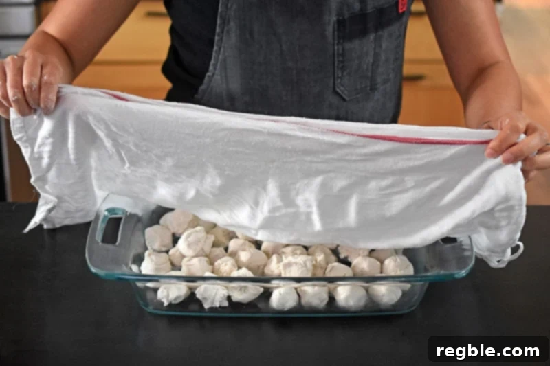 Cover the dough balls with a damp kitchen cloth to keep them from drying out.