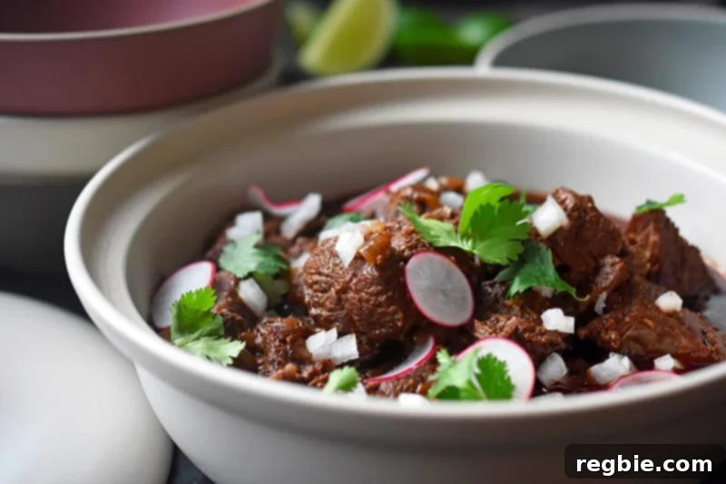 Side close-up of Instant Pot Cowboy Chili in a cream colored ceramic container, garnished and ready to eat.