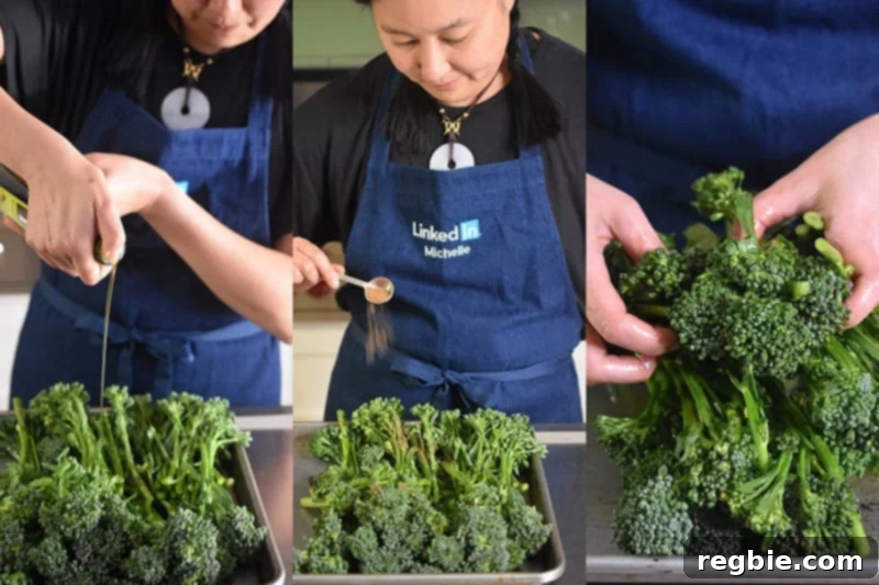 A woman's hands are tossing broccolini with olive oil and Magic Mushroom Powder on a rimmed baking sheet, preparing it for roasting.