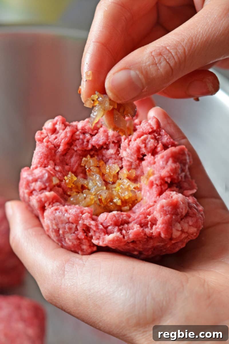 A teaspoon of cooked shallots is carefully added to a beef "bowl" before sealing.