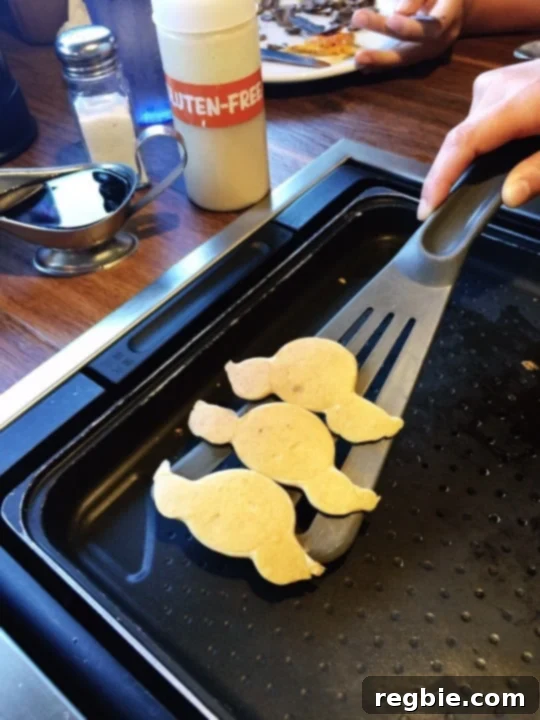 A spatula is picking up gluten-free pancakes from the griddle at Slappy Cakes in Maui
