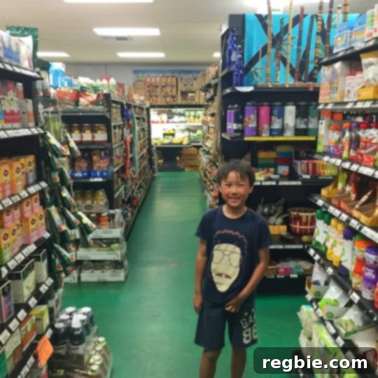 A smiling Asian boy is in the middle of a grocery store in Maui