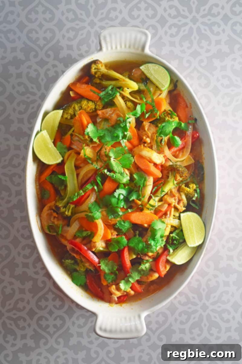 An overhead shot of a vibrant Thai Chicken Curry Casserole, garnished with fresh herbs, ready to be served from a white casserole dish.
