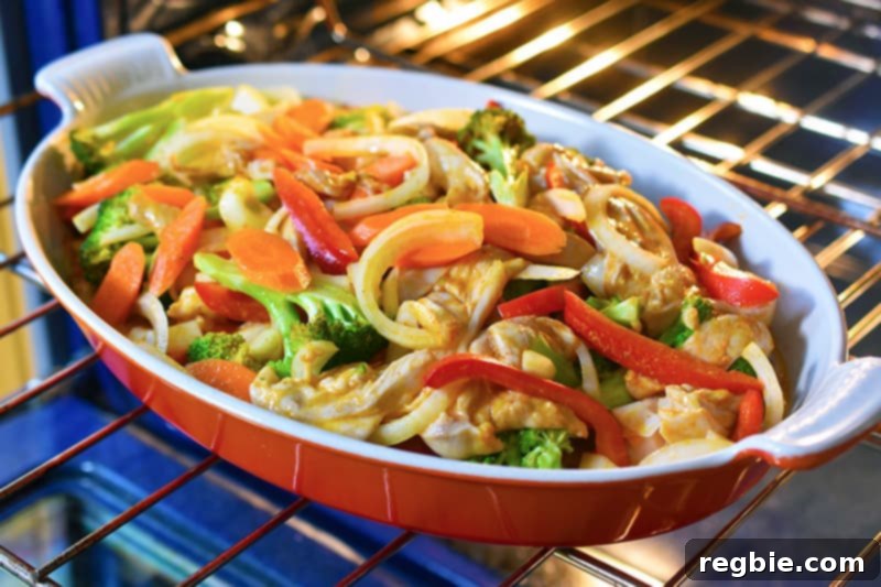 The Thai Chicken Curry Casserole, with the foil cover removed, is shown cooked and bubbling, garnished with fresh herbs, ready to be served.