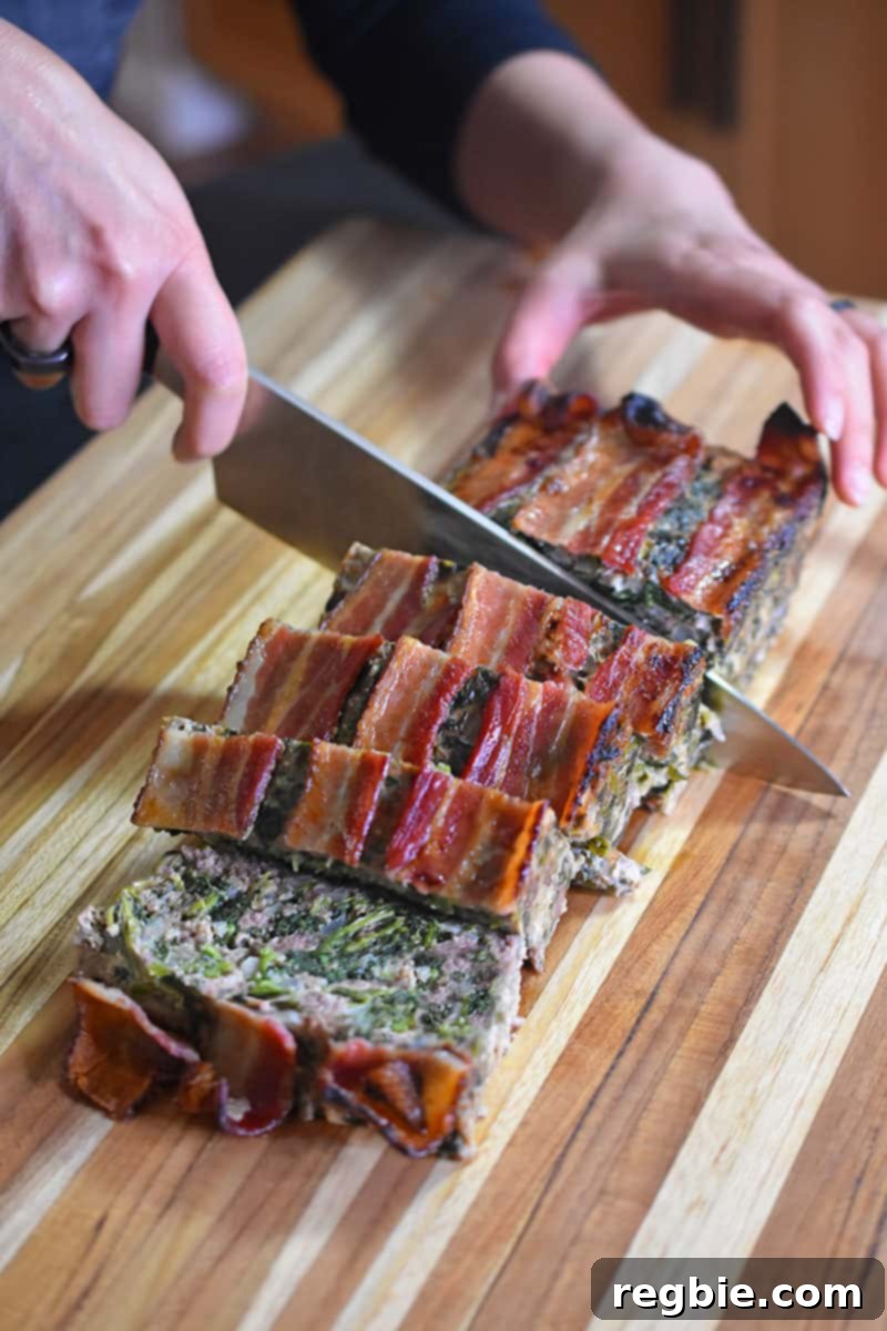 Easy Whole30 Paleo Keto Meatloaf Nut and Dairy Free 14 Slicing the Easy Paleo and Keto Meatloaf on a wooden cutting board, revealing its tender, vegetable-infused interior.