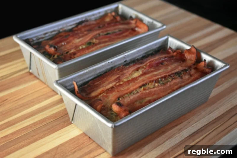 Easy Whole30 Paleo Keto Meatloaf Nut and Dairy Free 15 A picture of two pans of Easy Paleo and Keto Meatloaf side-by-side on a wooden cutting board, illustrating the smart meal prep strategy of doubling the recipe.
