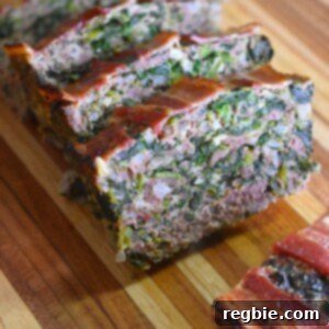 A closeup shot of sliced Easy Paleo and Keto Meatloaf on a wooden cutting board, ready for serving.
