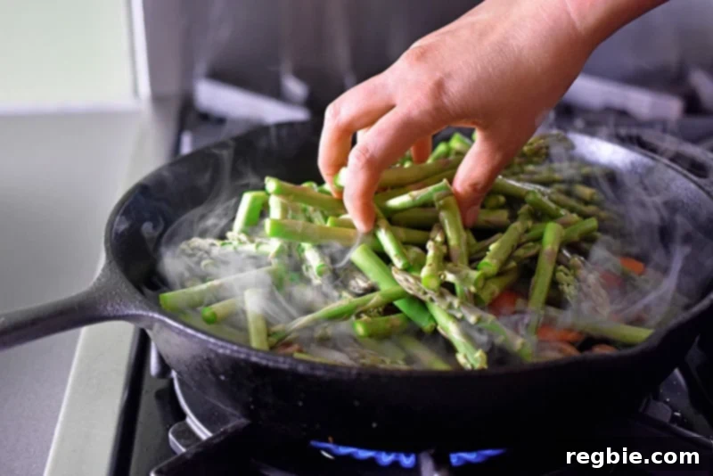 Photo of various fresh ingredients being carefully placed into a hot skillet for a healthy stir-fry.