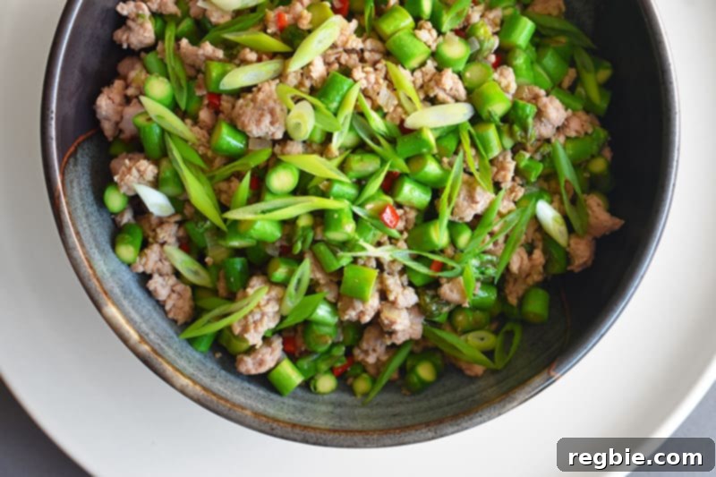 An overhead shot of vibrant Spicy Pork and Asparagus Stir-Fry served in a bowl, a quick and healthy weeknight meal.