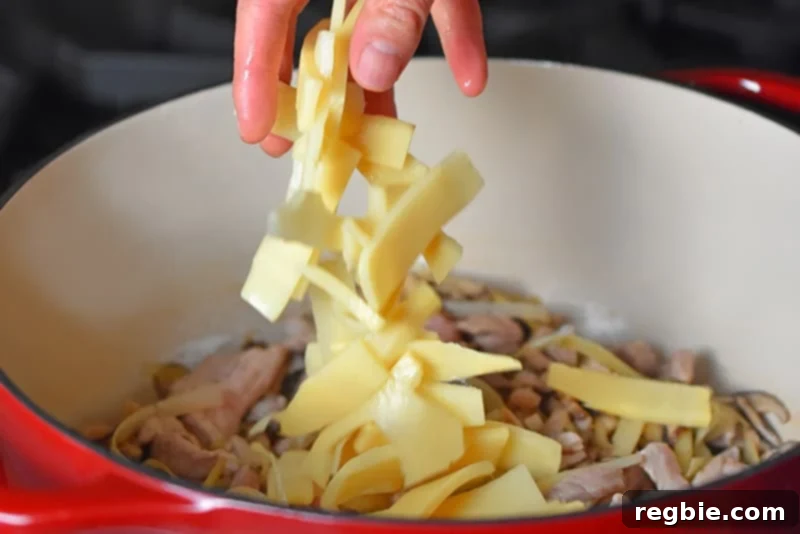 Zesty Whole30 Gluten Free Hot and Sour Soup 6 Adding sliced bamboo shoots to the pork and vegetable mixture for Hot and Sour Soup, infusing with garlic and ginger.