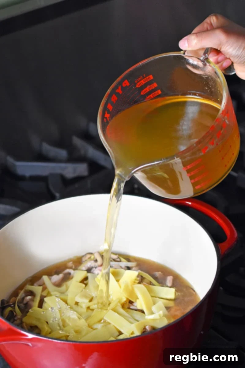 Zesty Whole30 Gluten Free Hot and Sour Soup 7 Pouring rich bone broth into the pot to create the base for Hot and Sour Soup.