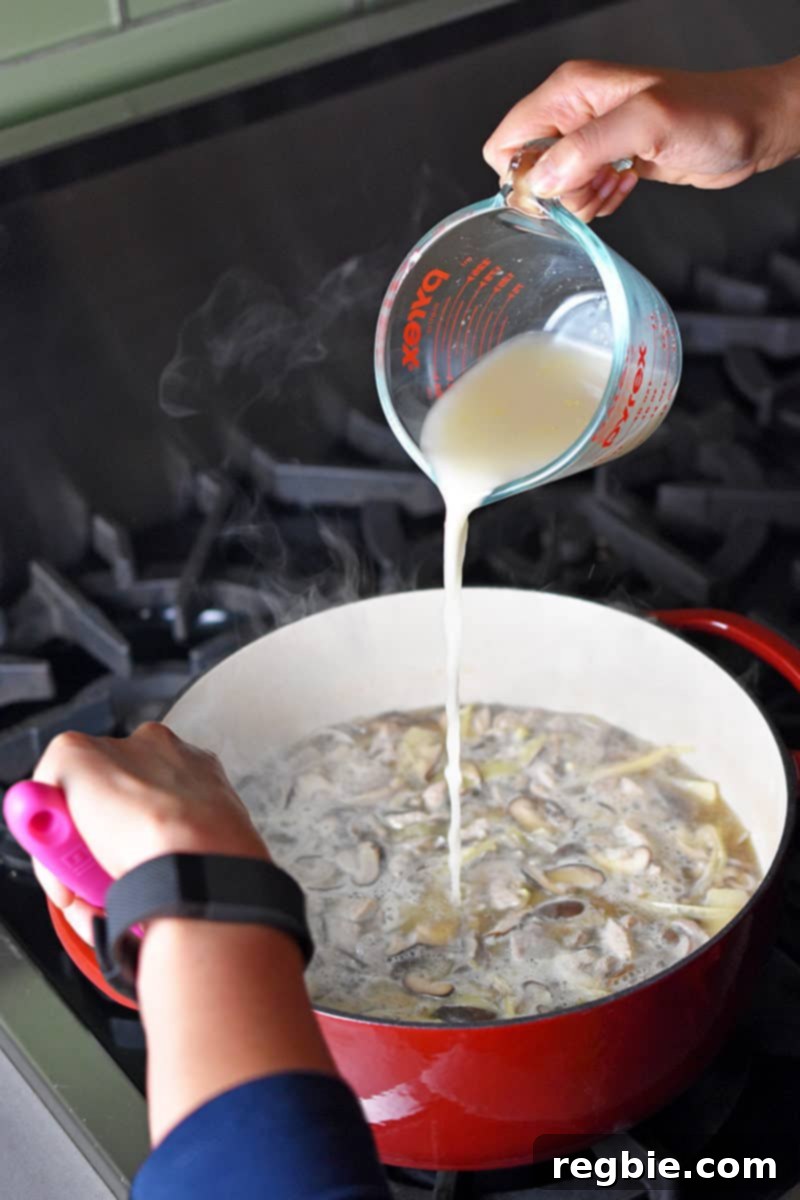 Zesty Whole30 Gluten Free Hot and Sour Soup 9 Pouring the arrowroot powder slurry into the simmering Hot and Sour Soup, stirring vigorously to thicken.