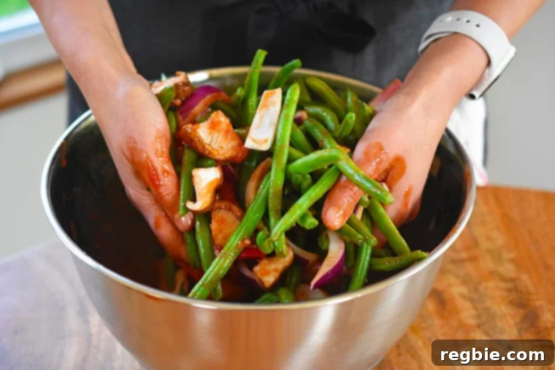 Sticky Sweet and Spicy Sheet Pan Pork 9 Tossing the vegetables in the marinade and coating well.