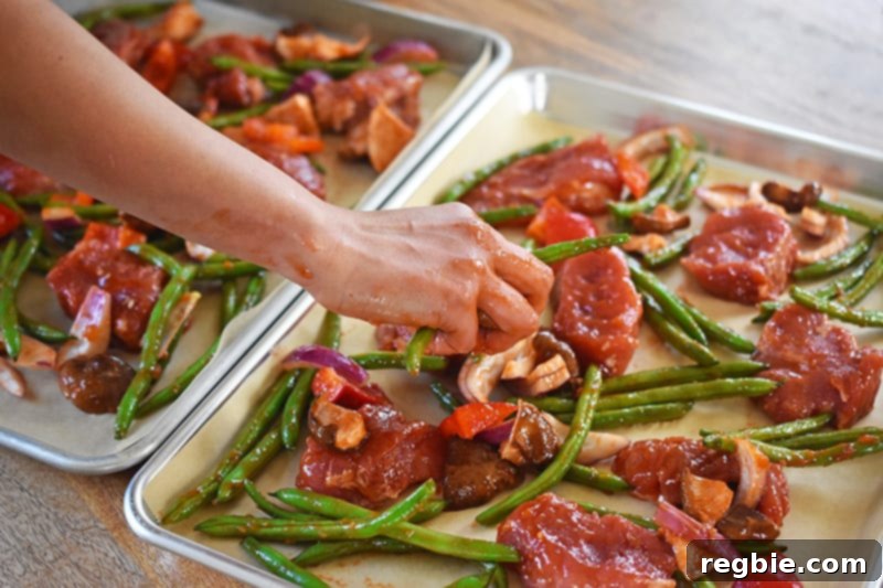 Sticky Sweet and Spicy Sheet Pan Pork 10 Dividing the pork and vegetables onto two parchment-lined rimmed baking sheets.