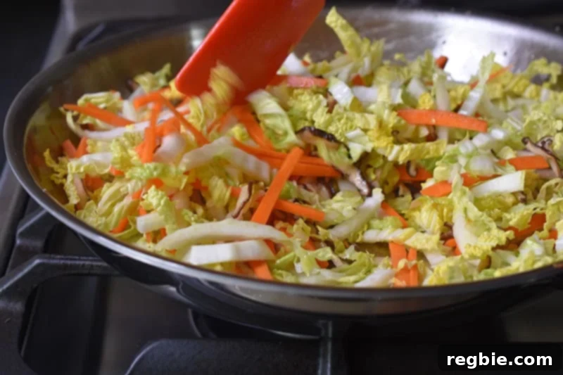 A side shot of the vegetables cooking in a large skillet.