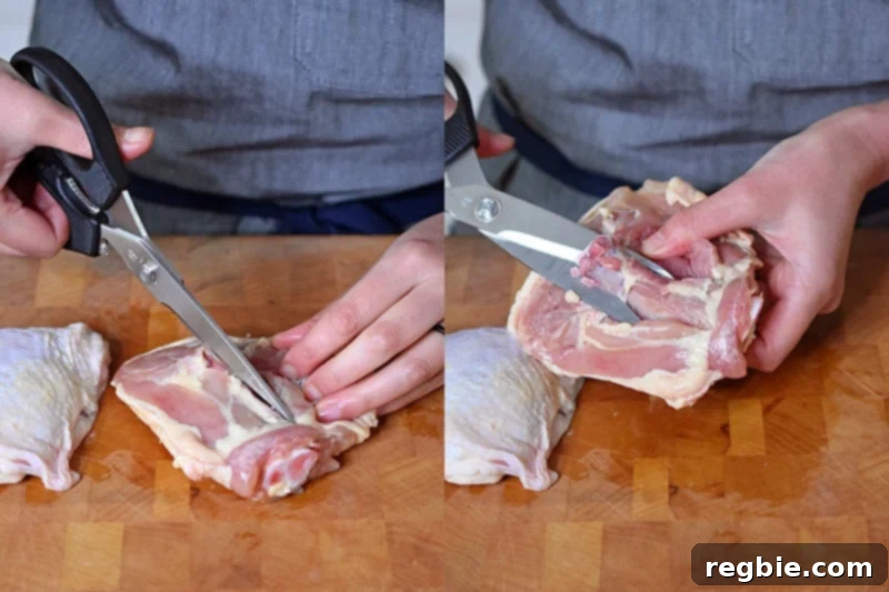 Ultimate Crispy Air Fryer Chicken Thighs 4 A person is using kitchen shears to carefully cut out the bone from chicken thighs, demonstrating the deboning process.