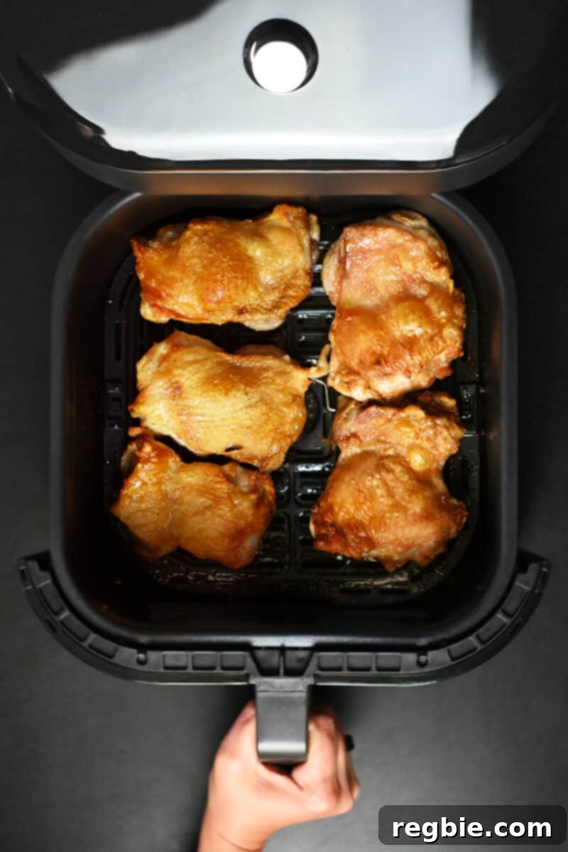 Ultimate Crispy Air Fryer Chicken Thighs 10 An overhead shot of an Instant Pot Vortex Plus air fryer with its ClearCook window, displaying the cooking process.