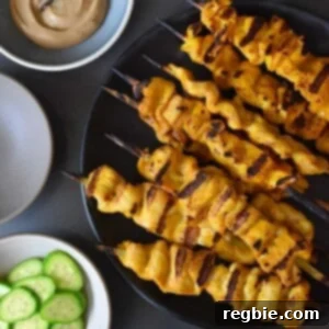 An overhead shot of Chicken Satay and Hoisin No-Nut Sauce along with some sliced cucumbers and cauliflower rice.