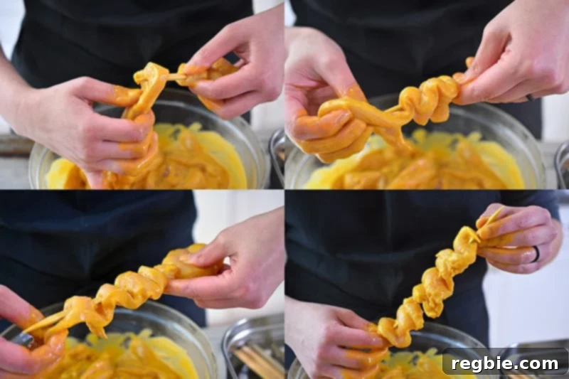 Showing the steps on how to properly skewer the marinated chicken strips onto a wooden skewer. The meat is tightly packed, like an accordion on the skewer, for optimal cooking.