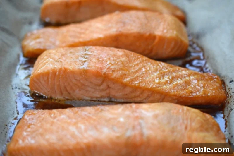 A close-up shot of perfectly baked easy teriyaki salmon, fresh out of the oven, revealing its moist and flaky texture.