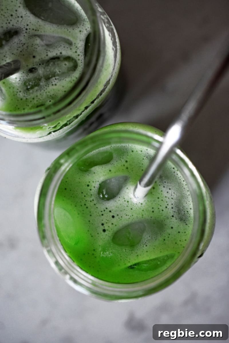 Chilled Matcha Infusion 11 An overhead shot of two mason jars filled with bright green cold brew matcha and ice, ready for immediate enjoyment.