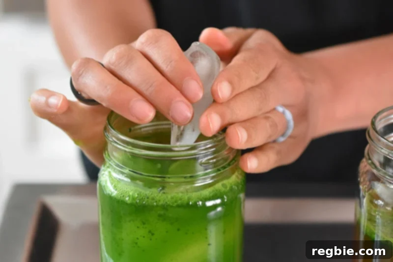 Chilled Matcha Infusion 8 Placing ice cubes into a jar filled with cold brew matcha ingredients before it is shaken up, ensuring optimal chilling and mixing.