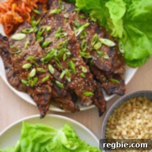 An overhead shot of paleo and Whole30 kalbi (Korean BBQ short ribs) served with Cauliflower rice, kimchi, and butter lettuce leaves.