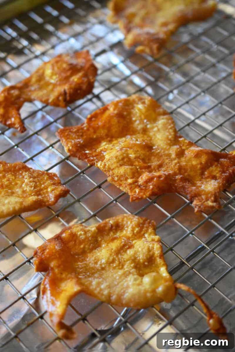 A tray of crispy chicken skin chips cooling on a wire rack after being baked to perfection.