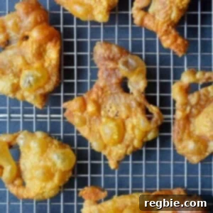 An overhead shot of Crispy Chicken Skin on a wire rack, the perfect paleo, Whole30, keto, and low carb snack.