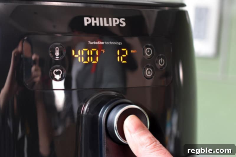 A person is programming an air fryer to cook at 400°F for 12 minutes, preparing for chicken cracklings.